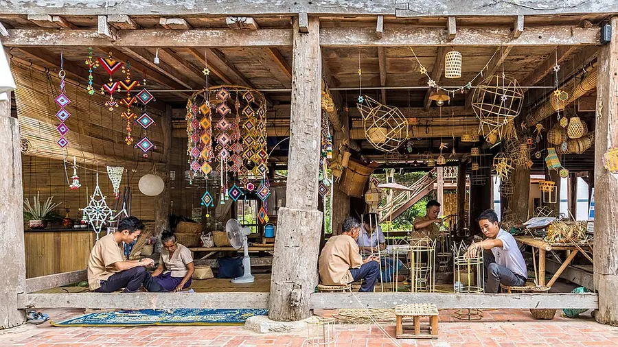 Artisan weaving bamboo strips into functional basketry