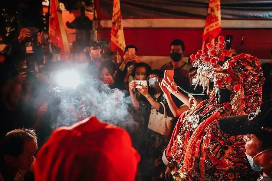 Mazu temple ceremony with pilgrims and incense smoke